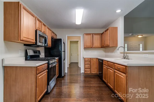a kitchen with stainless steel appliances granite countertop a stove a sink dishwasher and a refrigerator
