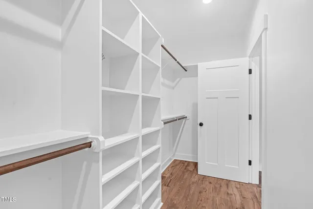 a view of a hallway with wooden floor and a window