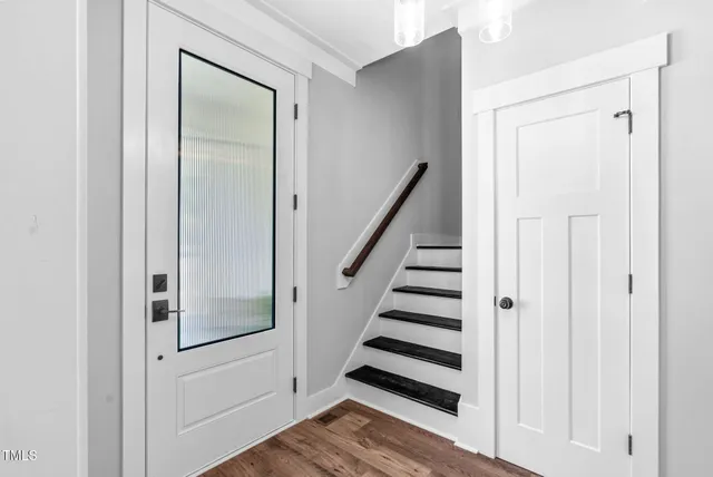 a view of empty room with wooden floor and fireplace