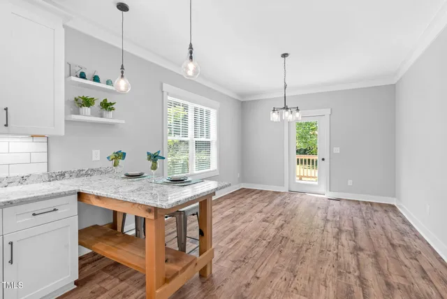 a big room with wooden floor and bathroom view