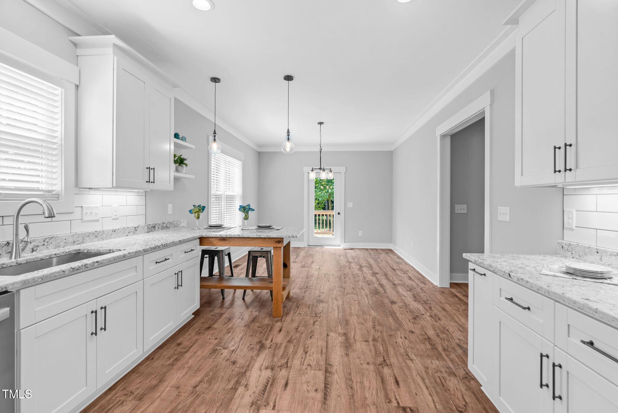 1004 Snow Peak Court Raleigh, NC 27603 - Photo 24 of 65 a kitchen with granite countertop a sink stove and white cabinets with wooden floor
