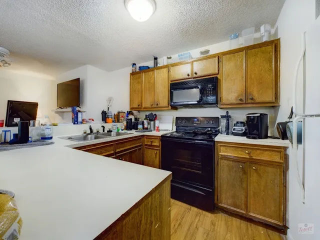 a kitchen with stainless steel appliances a stove a sink a microwave a refrigerator and cabinets