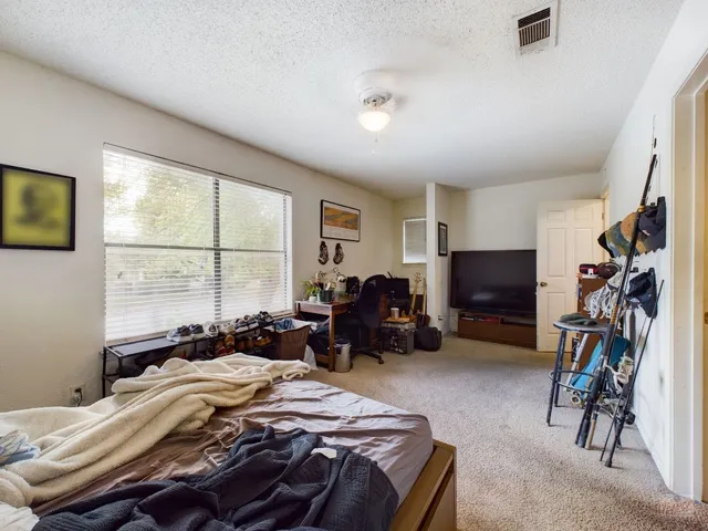 a bed room with a bed a television and a large window