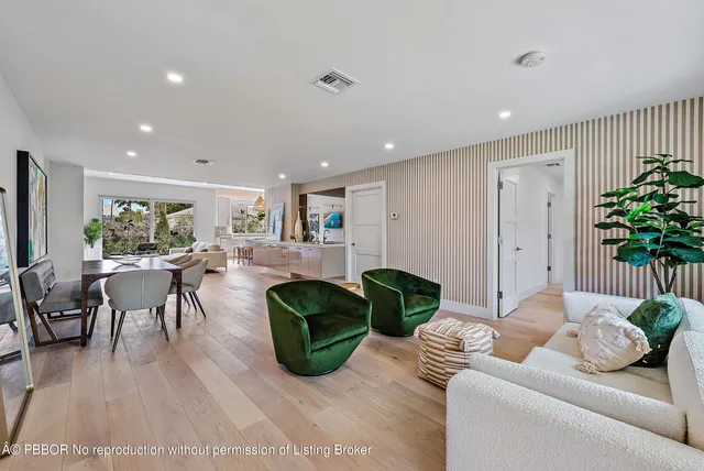a living room with furniture potted plant and kitchen view