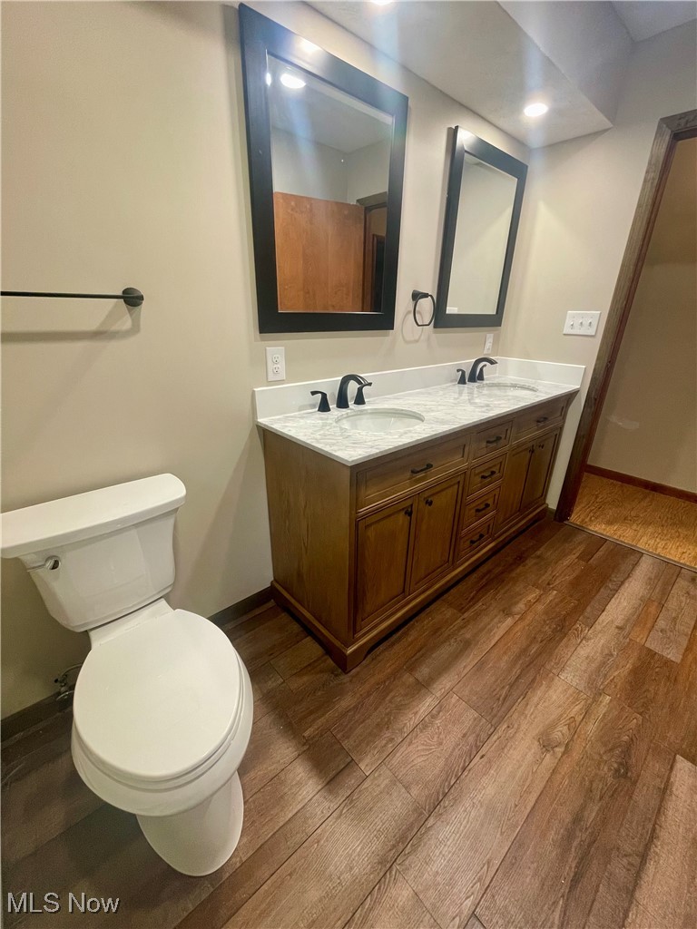 7815 Cemetery Road Vermilion, OH 44089 - Photo 4 of 43 Bathroom featuring hardwood / wood-style floors, vanity, and toilet