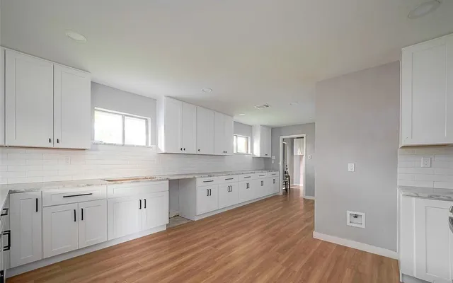 a view of a kitchen with wooden floor and electronic appliances