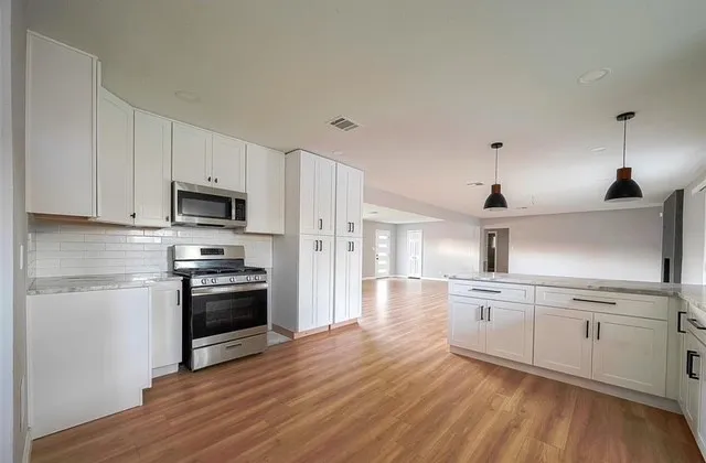 a kitchen with stainless steel appliances and white cabinets
