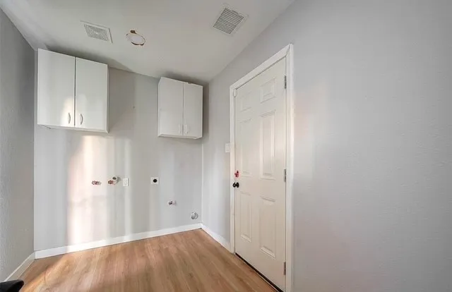a view of a hallway with wooden floor and closet area
