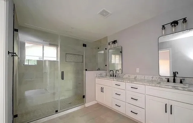 a bathroom with double sink and a mirror