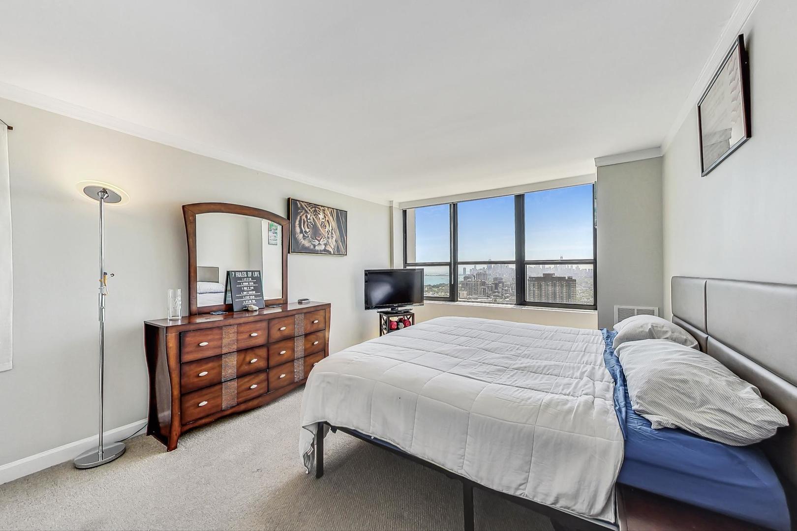 655 West Irving Park Road, Unit 5503 Chicago, IL 60613 - Photo 13 of 32 a bedroom with a bed a dresser and large mirror