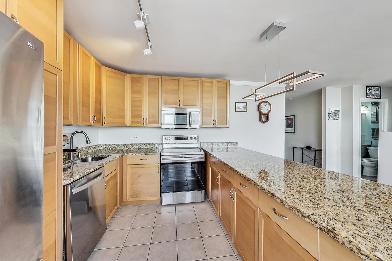 655 West Irving Park Road, Unit 5503 Chicago, IL 60613 - Photo 7 of 32 a large kitchen with a stove sink and cabinets