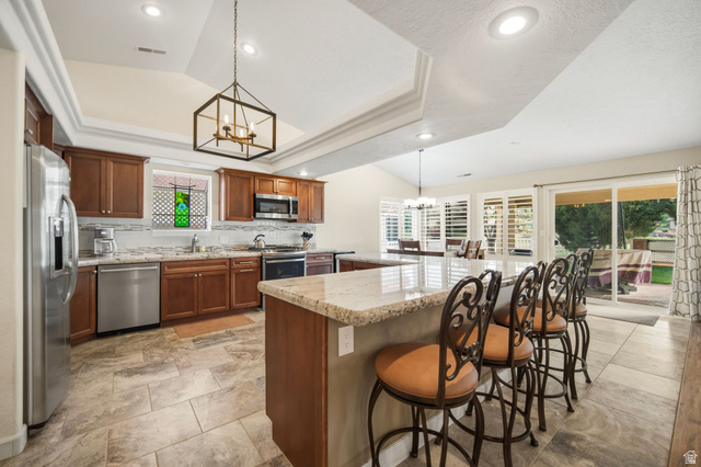 1985 West Rivers Edge Lane St. George, UT 84770 - Photo 19 of 42 Kitchen featuring hanging lights, stainless steel appliances, light stone counters, a breakfast bar, and a center island