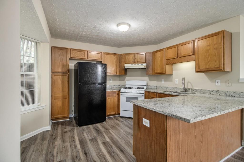 6510 Charter Way Lithonia, GA 30058 - Photo 12 of 27 a kitchen with a refrigerator a stove a sink dishwasher with wooden floor