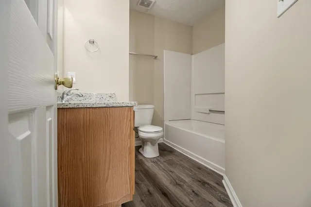 a bathroom with a granite countertop toilet sink and shower