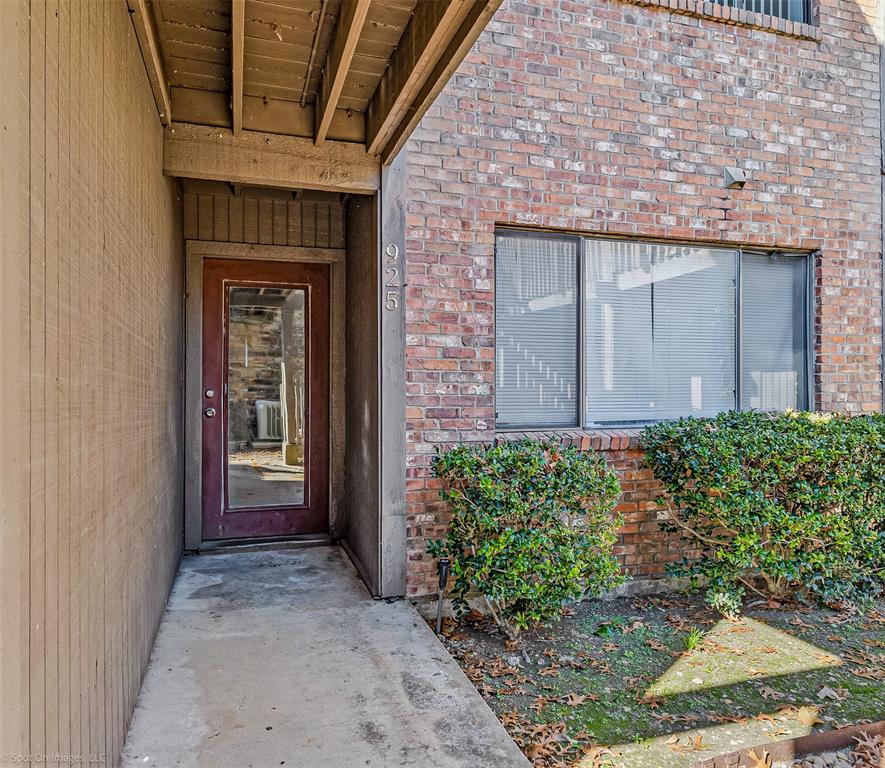a view of a brick house with potted plants