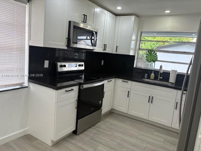 12328 Southwest 259th Street Homestead, FL 33032 - Photo 3 of 18 a kitchen with stainless steel appliances a stove microwave and cabinets
