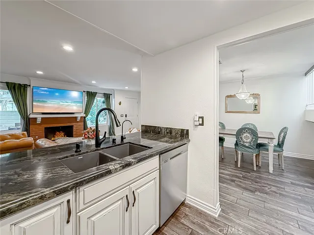 a kitchen with stainless steel appliances granite countertop a sink and a refrigerator
