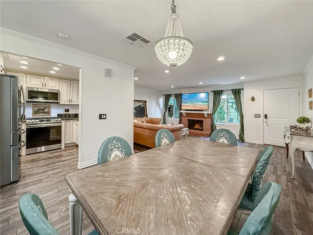 a view of a dining room with furniture a chandelier and wooden floor