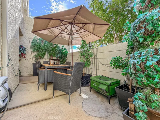 a view of a patio with table and chairs under an umbrella