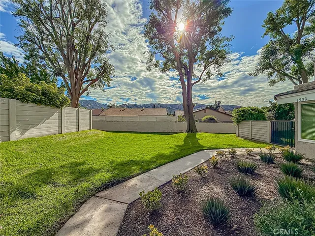 a view of a house with a big yard and large trees