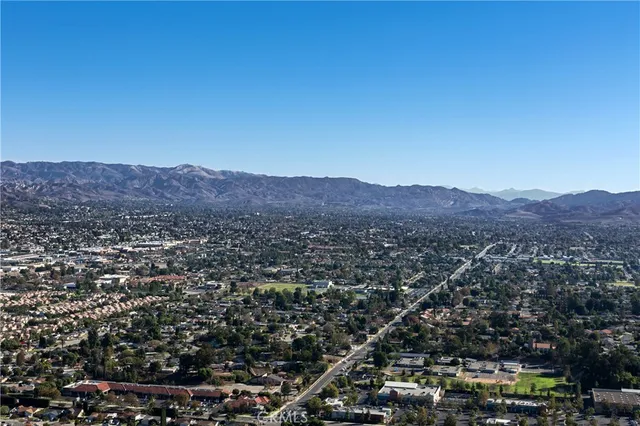 a view of a lush green field with mountains in the background