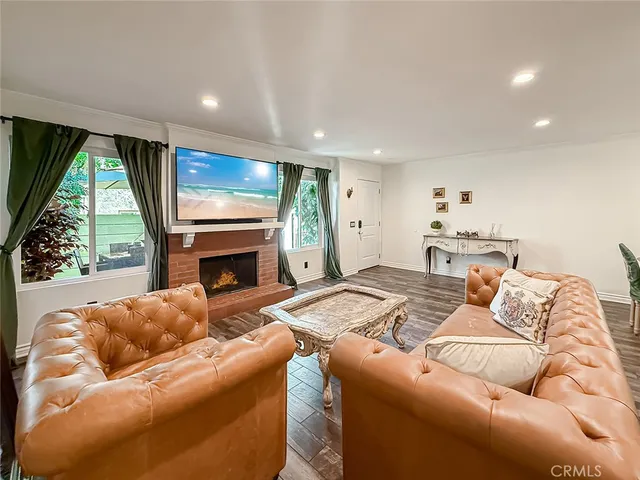a living room with furniture a fireplace and a large window