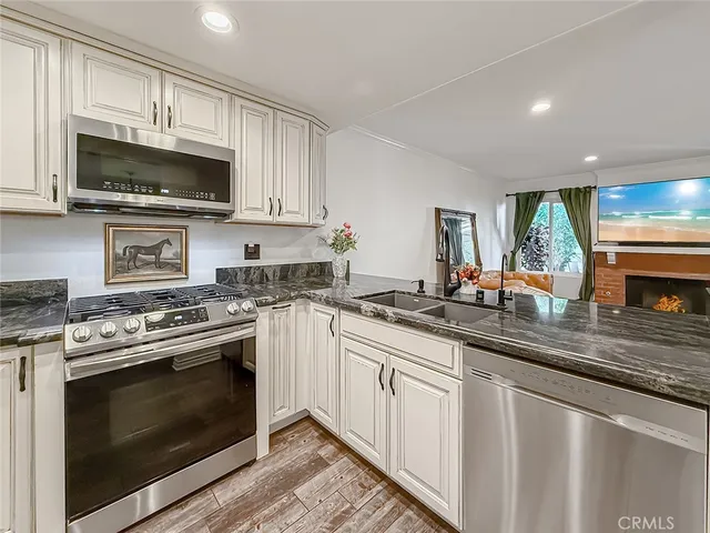 a kitchen with stainless steel appliances granite countertop a sink and a stove top oven