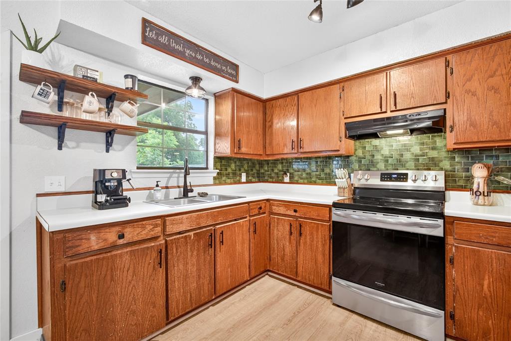 703 College Street Celeste, TX 75423 - Photo 12 of 29 a kitchen with stainless steel appliances granite countertop a sink a stove and a wooden floors