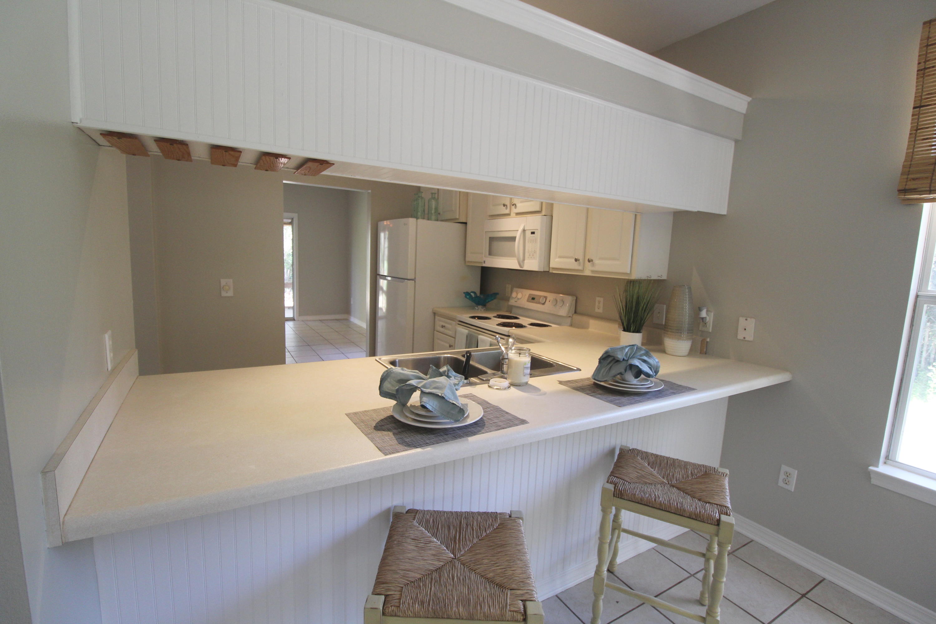 91 Walnut Street Santa Rosa Beach, FL 32459 - Photo 14 of 39 a kitchen with a sink a stove and chairs