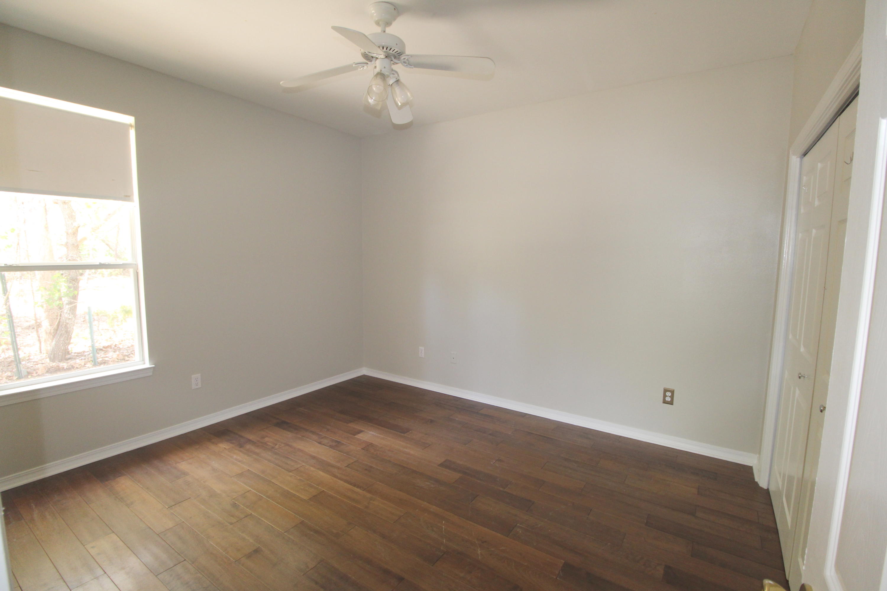 91 Walnut Street Santa Rosa Beach, FL 32459 - Photo 22 of 39 an empty room with wooden floor closet and windows