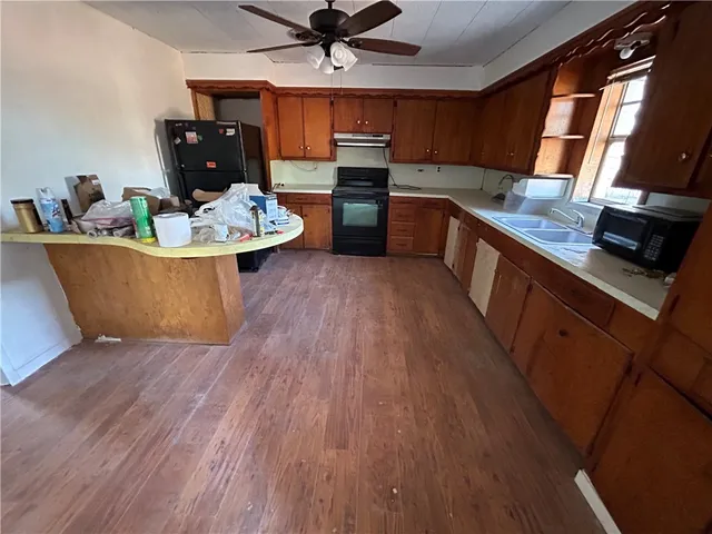 a kitchen with sink a microwave a stove and refrigerator