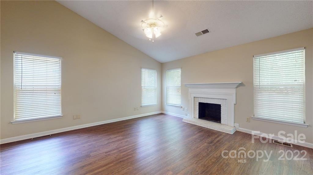 6401 Mounting Rock Road Charlotte, NC 28217 - Photo 14 of 35 a view of an empty room with wooden floor fireplace and a window