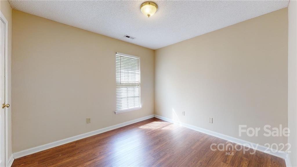 6401 Mounting Rock Road Charlotte, NC 28217 - Photo 21 of 35 an empty room with wooden floor and windows