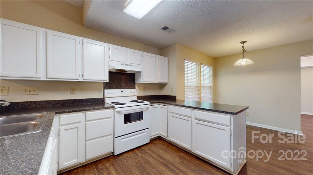 6401 Mounting Rock Road Charlotte, NC 28217 - Photo 10 of 35 a kitchen with granite countertop white cabinets and white appliances