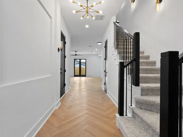 a view of a hallway with wooden floor and staircase