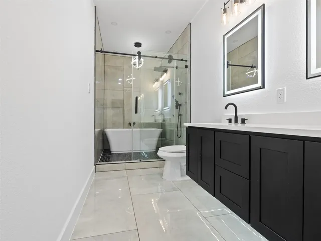 a bathroom with a sink a toilet and shower