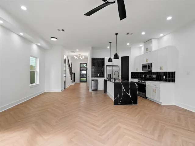 a kitchen with stainless steel appliances kitchen island sink refrigerator and microwave