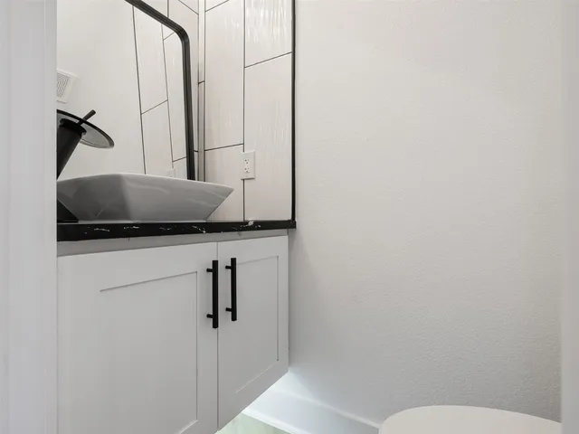 a bathroom with a granite countertop sink and toilet