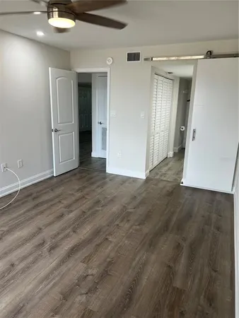 an empty room with wooden floor and a bathroom