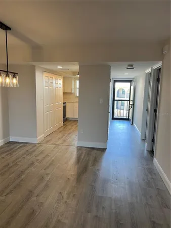 a view of a hallway with wooden floor and a living room