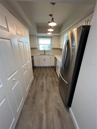 a view of a refrigerator in kitchen and wooden floor