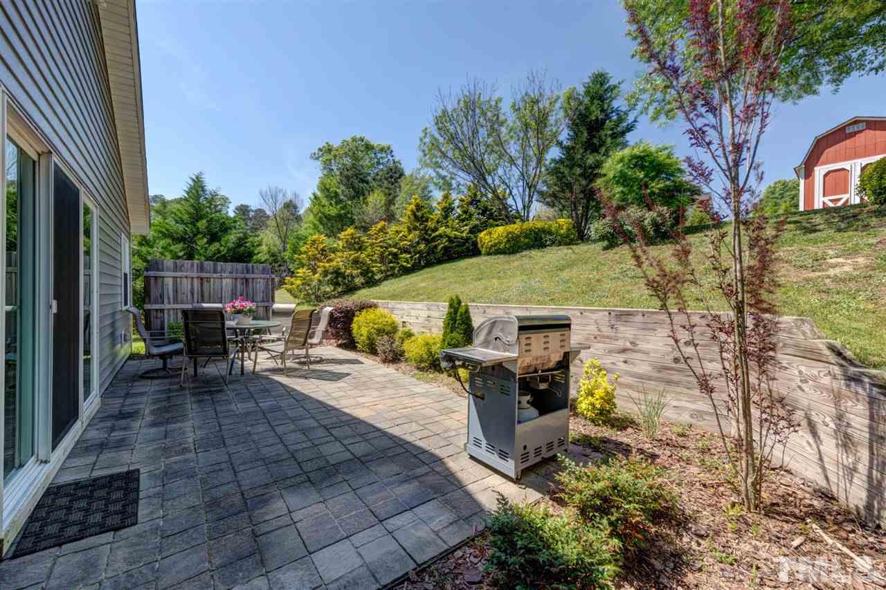 4845 Silverdene Street Raleigh, NC 27616 - Photo 23 of 24 a view of a patio with table and chairs with wooden fence and plants