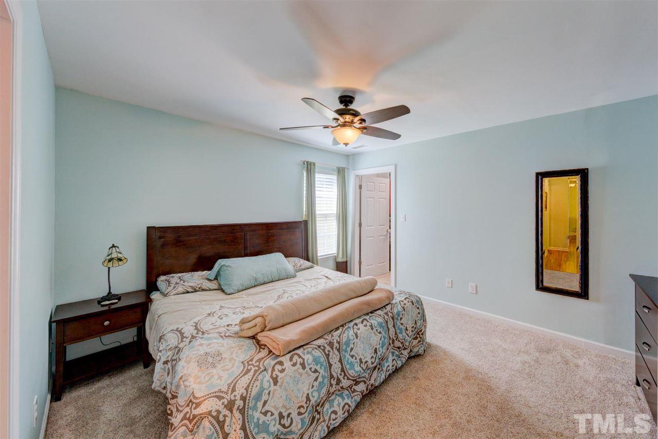 4845 Silverdene Street Raleigh, NC 27616 - Photo 9 of 24 a bedroom with a bed and a chandelier