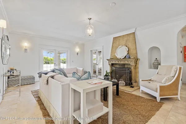 a living room with furniture a fireplace and a chandelier
