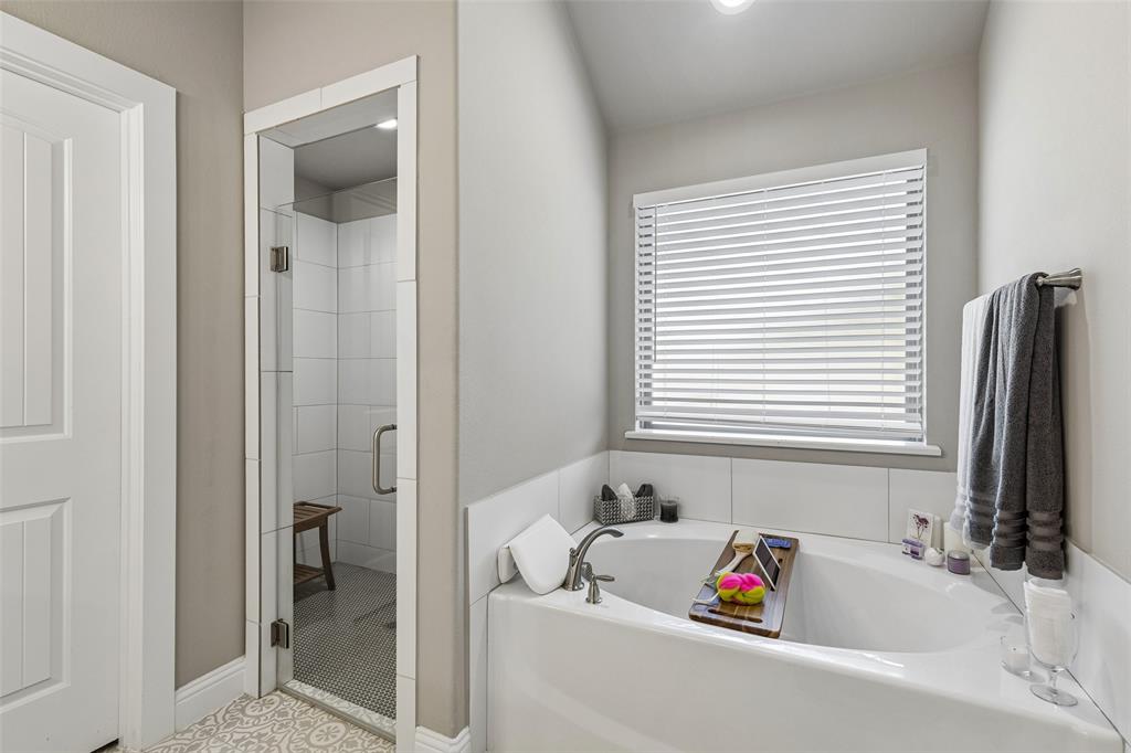108 Maverick Lane Pilot Point, TX 76258 - Photo 19 of 27 Soaking tub with white tile surround and a window with blinds