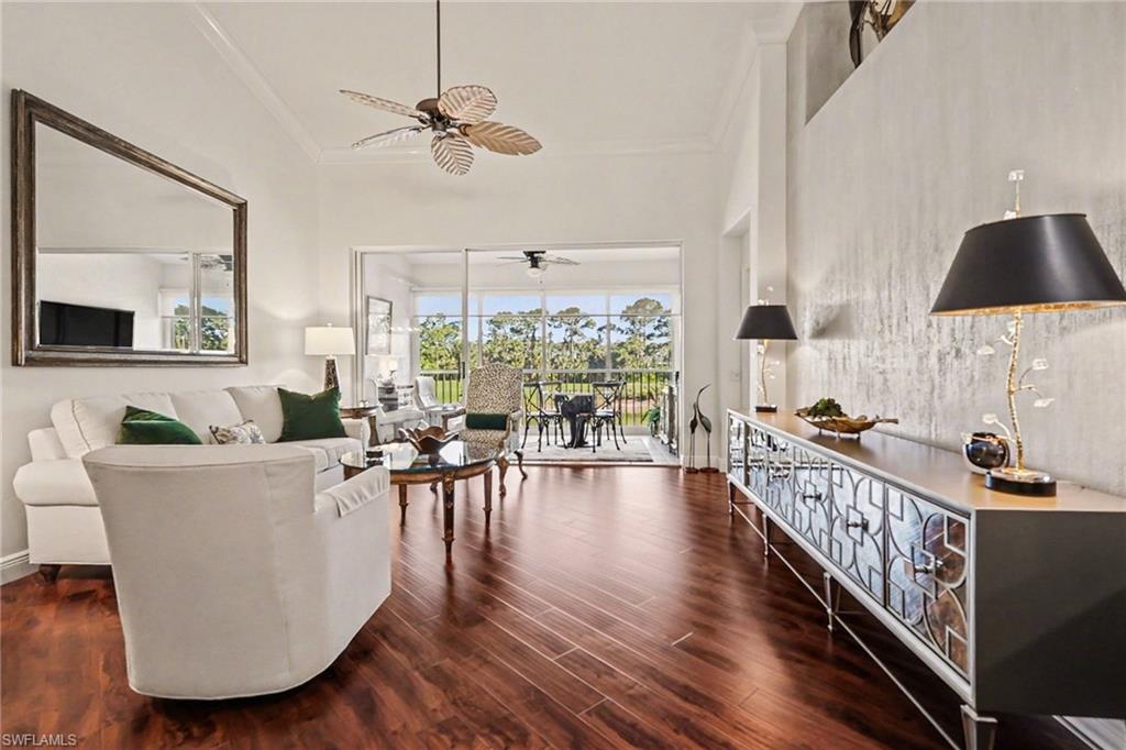 9341 Spring Run Boulevard, Unit 3108 Estero, FL 34135 - Photo 2 of 30 Living area featuring dark wood-style flooring, crown molding, and a ceiling fan