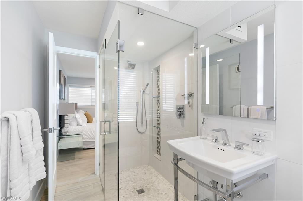 175 5th Avenue South, Unit 3 Naples, FL 34102 - Photo 15 of 31 a bathroom with a sink a toilet a mirror and shower