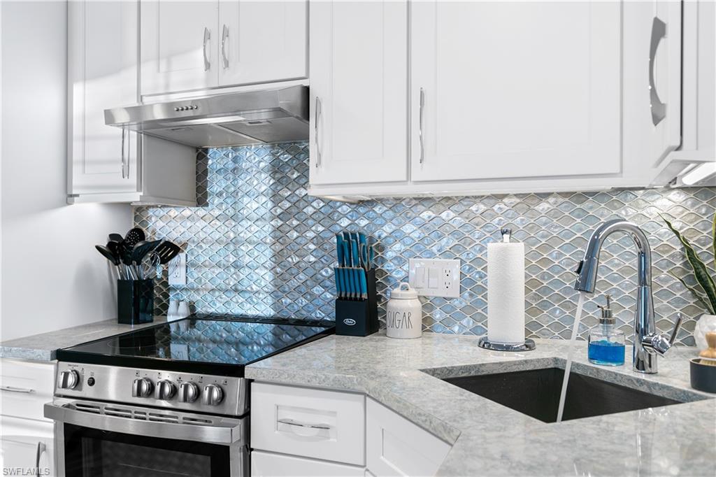 175 5th Avenue South, Unit 3 Naples, FL 34102 - Photo 8 of 31 a kitchen with granite countertop a stove and a sink