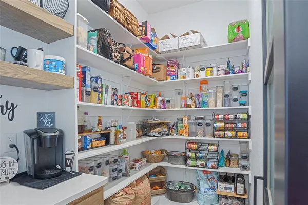 a room with a fridge and a shelf