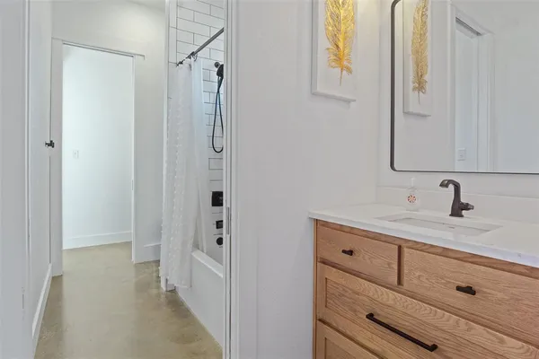 a bathroom with a granite countertop sink a mirror and a shower